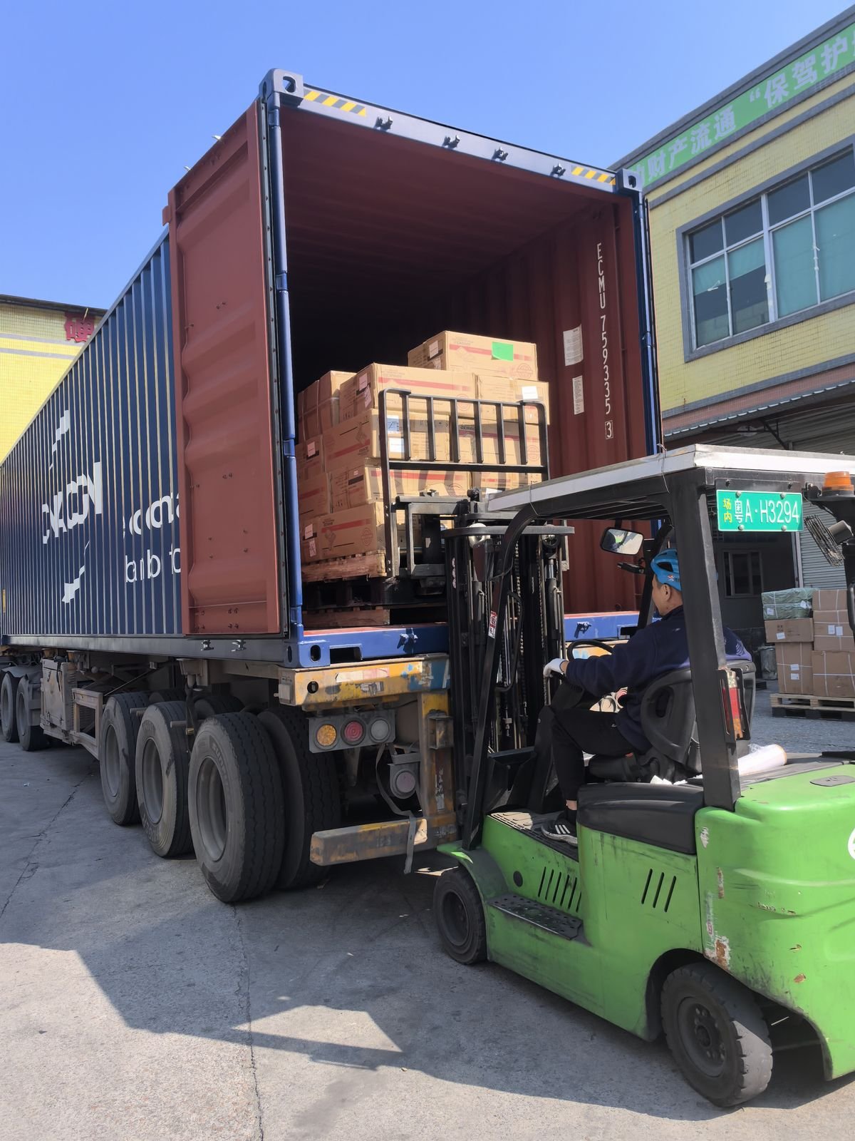 Forklift loading cargo into shipping container at Dongguan warehouse